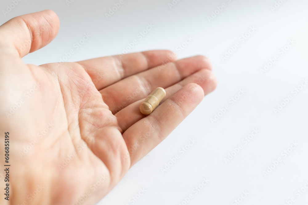 Ashwagandha capsule held in hand on light background, healthy lifestyle Ashwagandha capsule held in hand on light background, healthy lifestyle