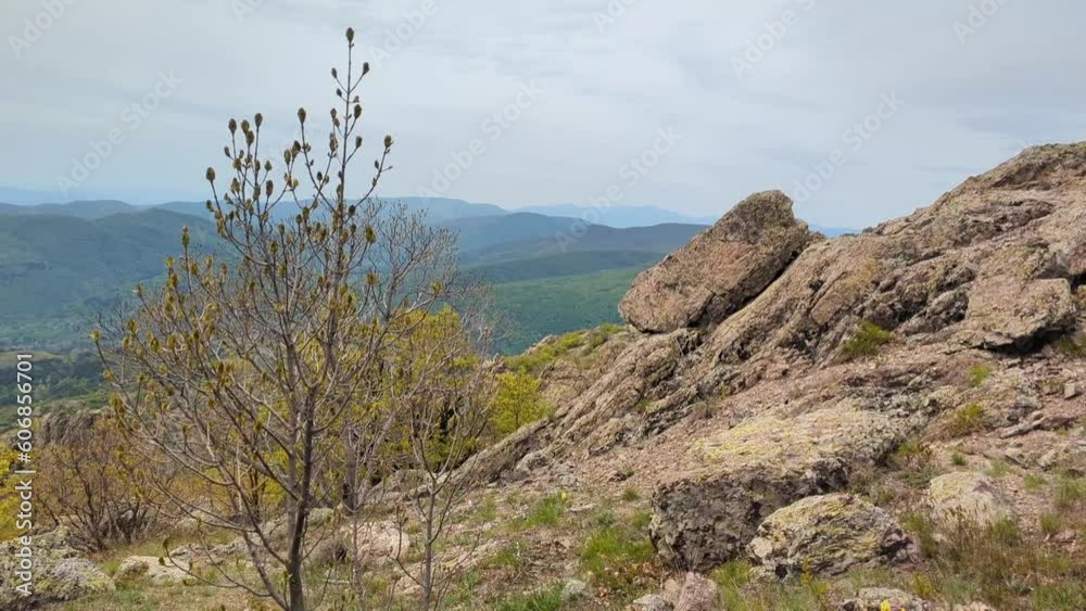 Panoramic view of the valley on top of the rocky ridge among the stones overlooking the beautiful valley. Outdoor and mountain hike background. Natural landscape in Bulgaria, Sliven Panoramic view of the valley on top of the rocky ridge among the stones overlooking the beautiful valley. Outdoor and mountain hike background. Natural landscape in Bulgaria, Sliven