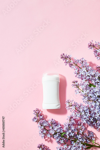White antiperspirant deodorant with lilac branches on a pink background