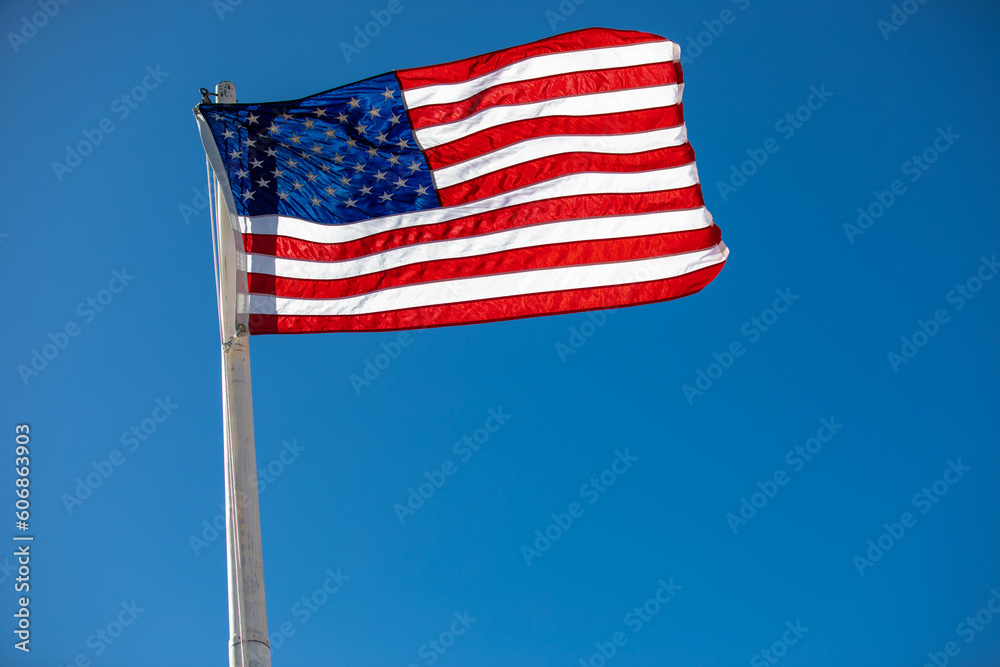 american flag waving in the wind being backlit by the sun