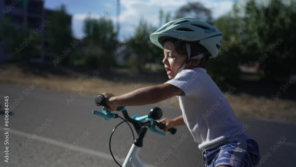 Child falling from bicycle while learning to ride. Small boy falls from bike