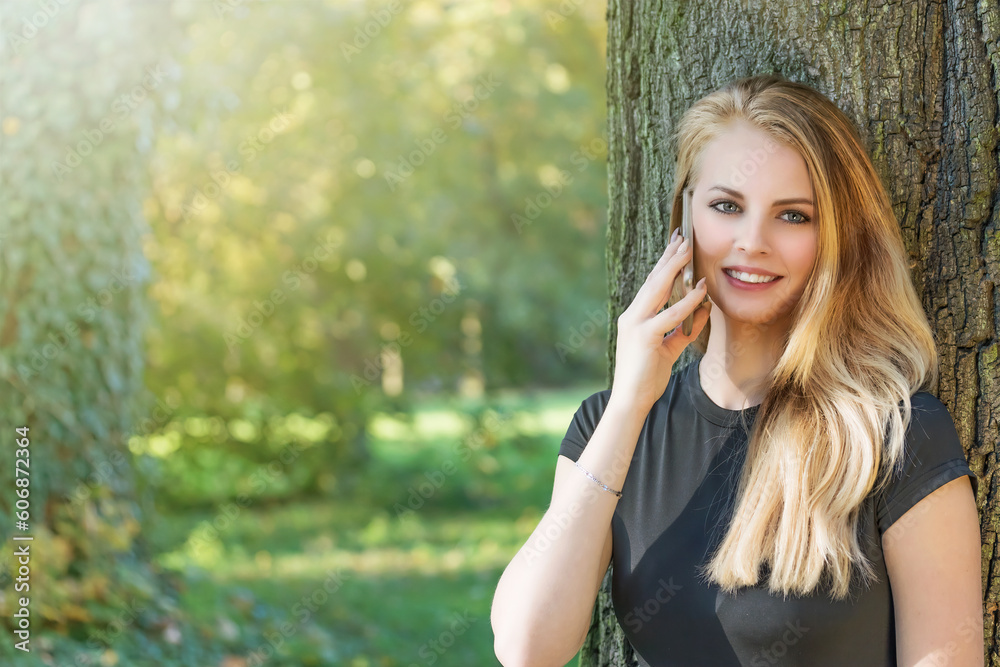 Attractive long haired young girl is on the phone outdoors . Horizontally. Attractive long haired young girl is on the phone outdoors . Horizontally.