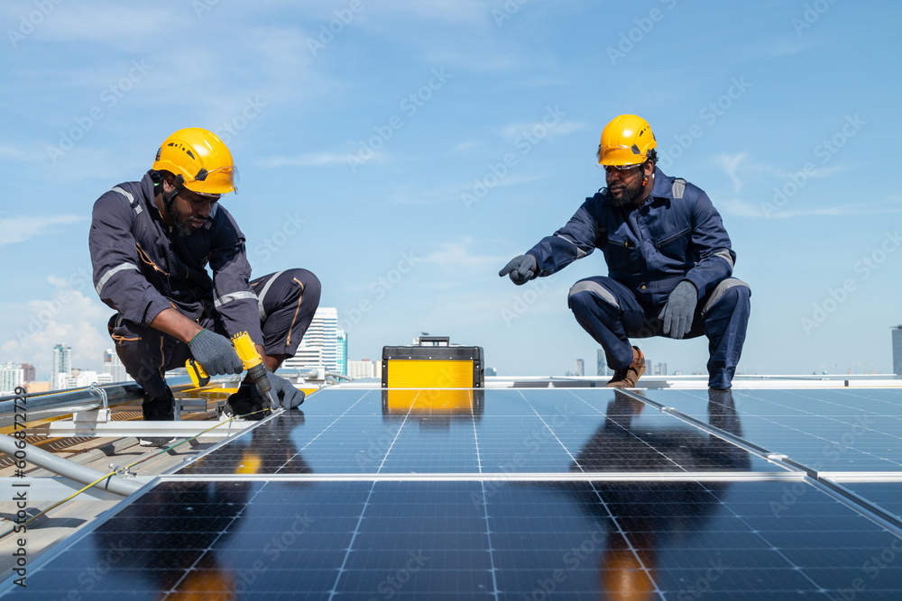 Engineers and technicians check drawings for installing solar cell panels on the roof. alternative energy energy from the sun Engineers and technicians check drawings for installing solar cell panels on the roof. alternative energy energy from the sun