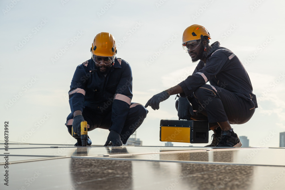 Engineers and technicians check drawings for installing solar cell panels on the roof. alternative energy energy from the sun Engineers and technicians check drawings for installing solar cell panels on the roof. alternative energy energy from the sun