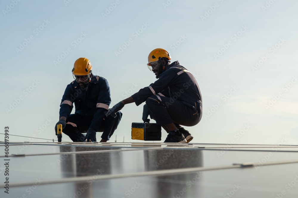 Engineers and technicians check drawings for installing solar cell panels on the roof. alternative energy energy from the sun Engineers and technicians check drawings for installing solar cell panels on the roof. alternative energy energy from the sun