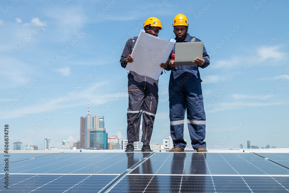 Engineers and technicians check drawings for installing solar cell panels on the roof. alternative energy energy from the sun Engineers and technicians check drawings for installing solar cell panels on the roof. alternative energy energy from the sun