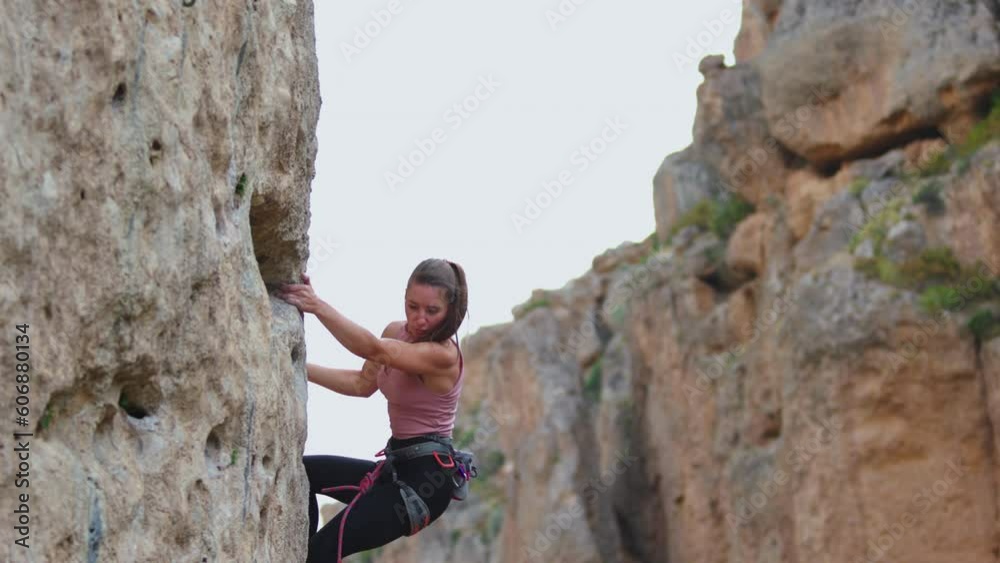 The girl climbs the rocks, rock climbing in nature. sports girl is engaged in rock climbing. extreme sport