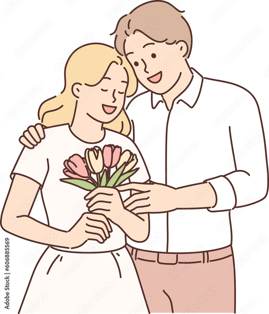 Loving man hugging woman giving bouquet flowers in honor anniversary relationship or Valentine Day