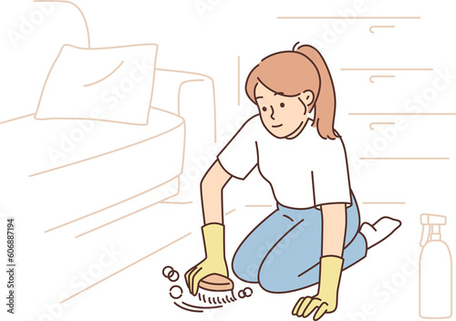 Woman cleans carpet using chemical detergent and brush to get rid of dust or stains