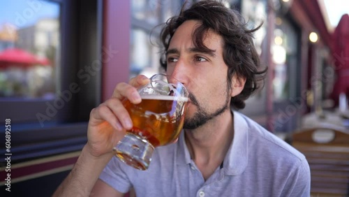 Wallpaper Mural One young man drinking beer outside in city sidewalk. Male person drinks draft pale ale beer at restaurant Torontodigital.ca