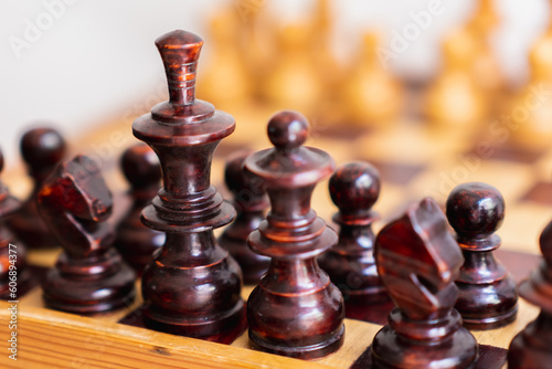 Detail photograph of dark chess pieces on top of game board  strategy game