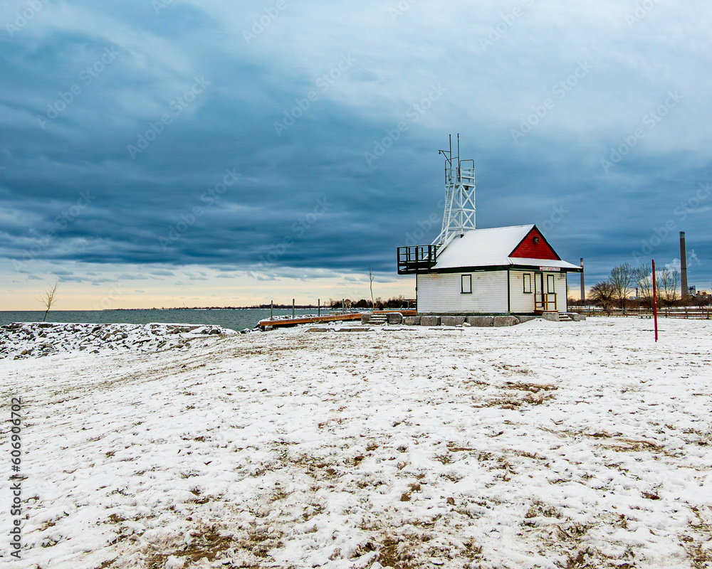 snow covered beach with grey blue storm clouds wooden lifeguard station. room for text