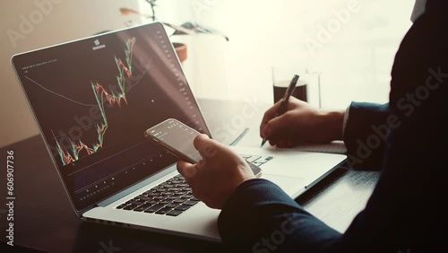 investment stockbroker risk analysis using multiple devices. Financial analysis using phone app and laptop. Market trading profit. 