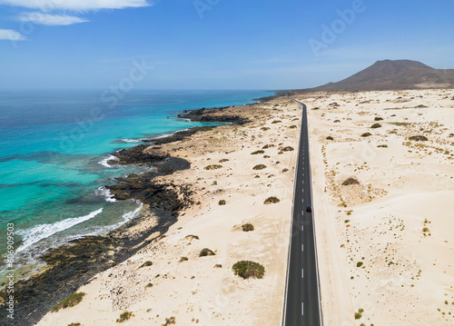 Aerial mid level panoramic view of the road between the coast and Parque Natural sand dunes heading out of Corralejo Fuerteventura Spain photo