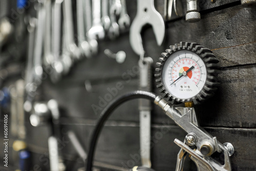 Pressure gauge and other tools on a board hanging on the wall of a bicycle repair shop.