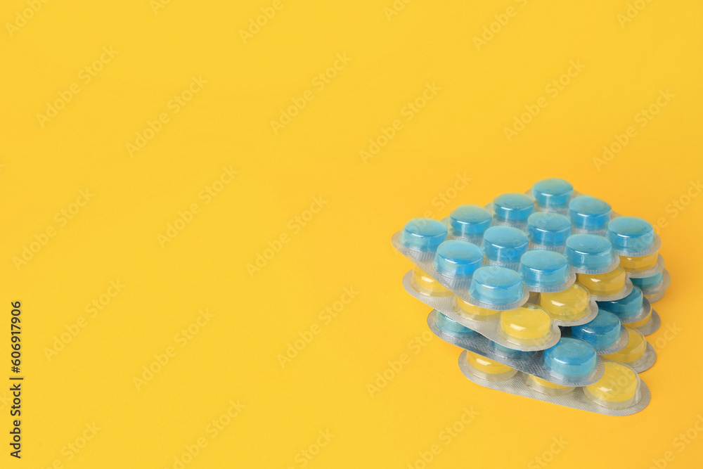Blisters with cough drops on yellow background. Space for text