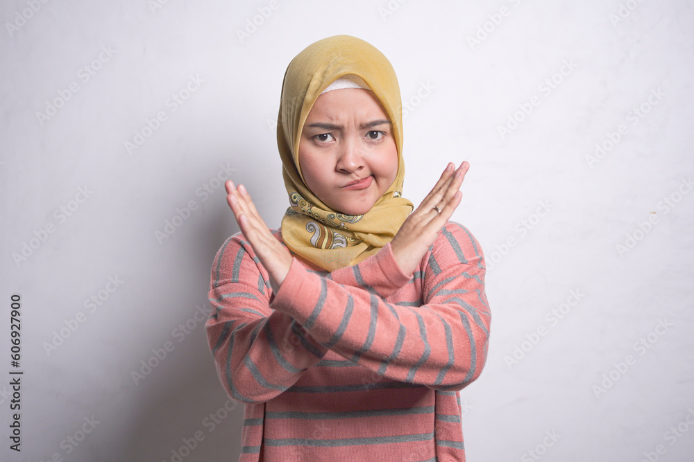 Portrait of angry young housewife woman in hijab doing stop gesture with crossed hands isolated on white background. People housewife muslim lifestyle concept Portrait of angry young housewife woman in hijab doing stop gesture with crossed hands isolated on white background. People housewife muslim lifestyle concept