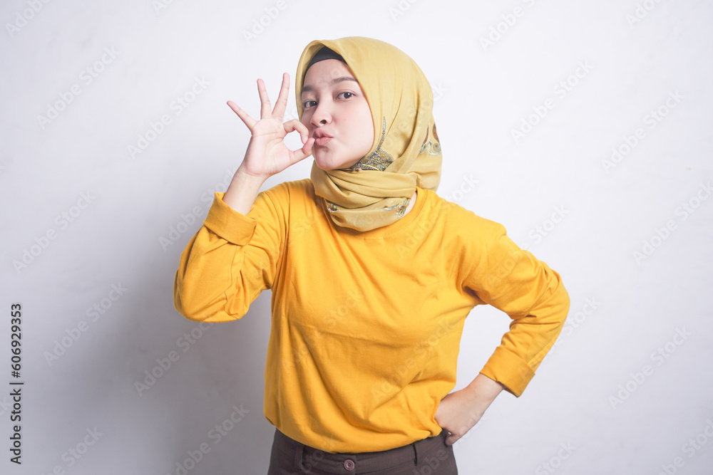 Portrait of beautiful muslim woman wearing orange t-shirt, smiling doing okay sign with hand Portrait of beautiful muslim woman wearing orange t-shirt, smiling doing okay sign with hand