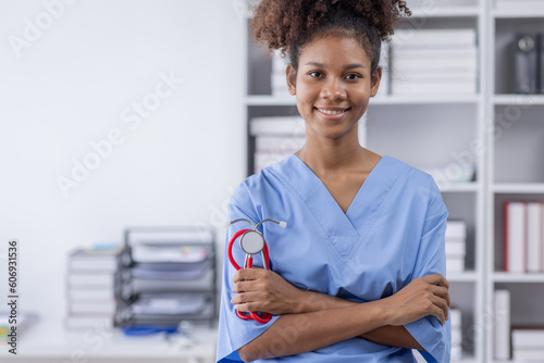 Happy doctor Portrait of young African American woman nurse or doctor smilingusing a laptop writing content at consultation photo