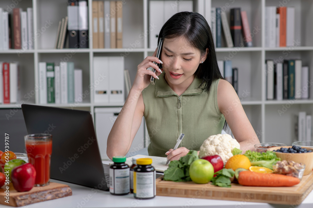 Asian woman professional nutritionist consulting with her client on the phone, surrounded by a variety of fruits, nuts, vegetables, and dietary supplements on the table Asian woman professional nutritionist consulting with her client on the phone, surrounded by a variety of fruits, nuts, vegetables, and dietary supplements on the table