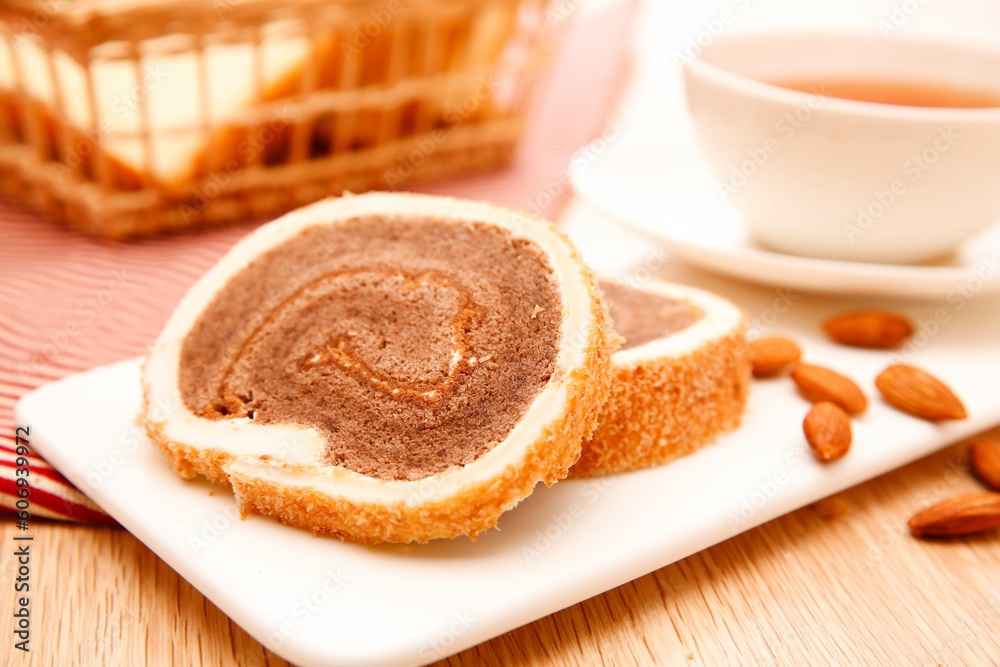 Chocolate swiss cake roll, on a tabletop on a white background, indoors, close-up Chocolate swiss cake roll, on a tabletop on a white background, indoors, close-up