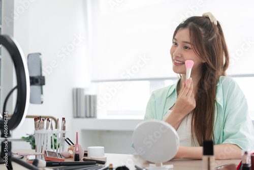 Beauty Vlogger concept, Young woman use brush to applying blush on cheek and review product in Vlog