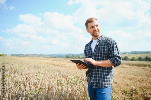 Man farmer in wheat field at sunset. Farming and agricultural harvesting