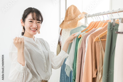 ガッツポーズをするショップ・服屋で働く笑顔の販売員・従業員・ショップ店員のアジア人女性 