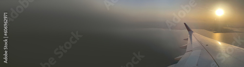 Wide template with space for text. Background of sunset. Wing of airplane, view from aircraft, flight. Horizontal backdrop with place for inscription. Idea for travel service, aviation, transportation