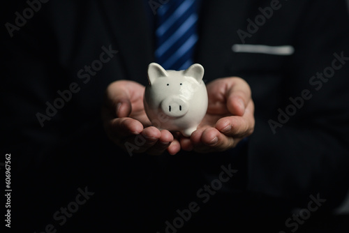 A person is holding a piggy bank, saving money and managing personal finances. Concept of increasing savings and savings by investing in stock mutual funds.