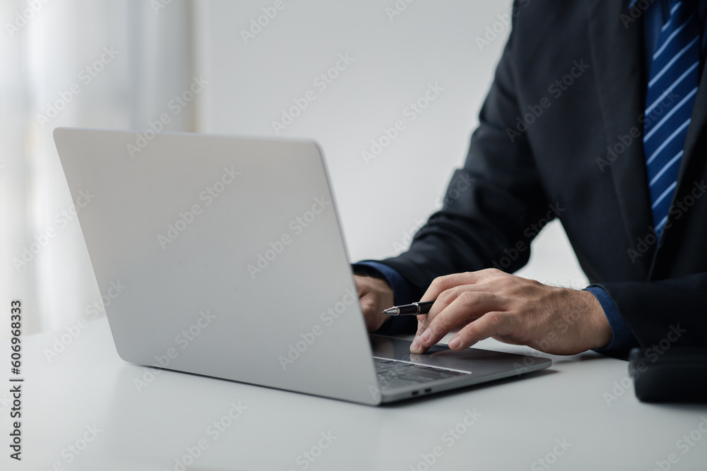 Person typing on laptop keyboard, businessman working on laptop, he is typing messages to colleagues and making financial information sheet to sum up the meeting. Person typing on laptop keyboard, businessman working on laptop, he is typing messages to colleagues and making financial information sheet to sum up the meeting.