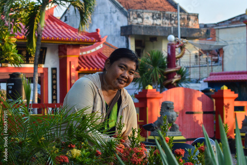 A Woman Enjoying Holiday In The Flower Garden In Front Of The Tri Dharma Vihara At Ling Gwan Kiong Temple Singaraja photo