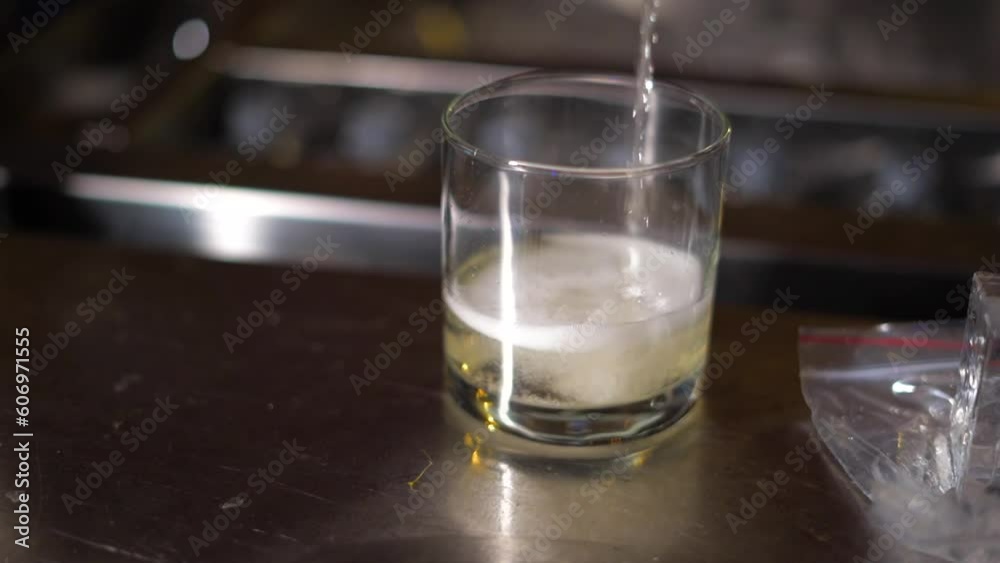 he is pouring a drink in a glass closeup view he is pouring a drink in a glass closeup view