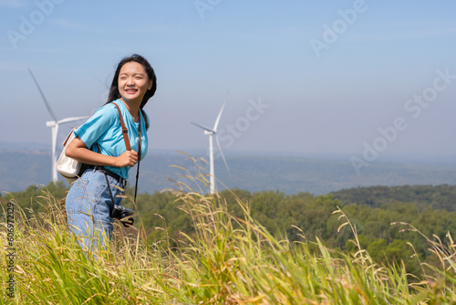 Traveler girl turn back looking beautiful view of mountain and Wind Turbine, Khao Yai Thieng Electric Wind Turbine Thailand. photo