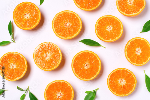 Orange slices with green leaves on white background, top view, flat lay. Oranges fruit texture pattern background.