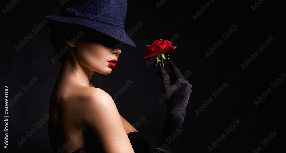 Fototapeta premium Beautiful young Woman In Hat and Gloves holding Flower. Lovely girl with make-up and Red Rose