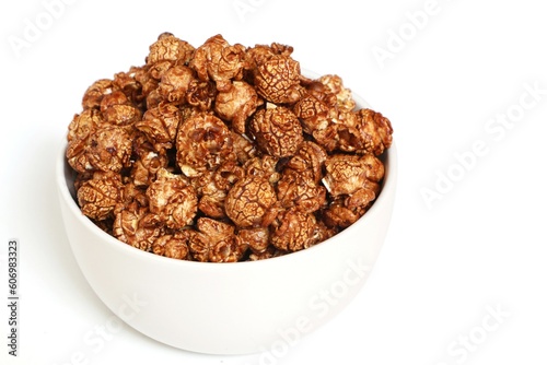 Popcorn with sweet chocolate caramel in white bowl on white background.