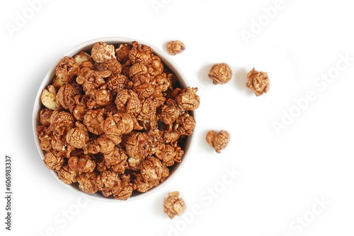 Popcorn with sweet chocolate caramel in white bowl on white background. Top view.
