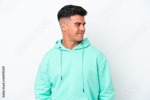 Young caucasian handsome man isolated on white background having doubts while looking side © luismolinero