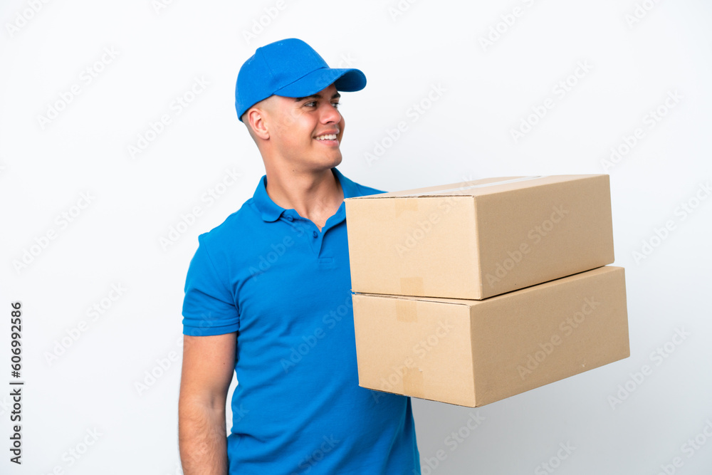 Delivery caucasian man isolated on white background looking to the side and smiling Delivery caucasian man isolated on white background looking to the side and smiling