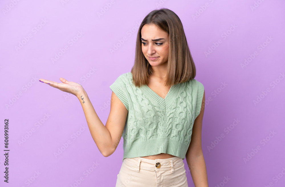 Young caucasian woman isolated on purple background holding copyspace with doubts Young caucasian woman isolated on purple background holding copyspace with doubts