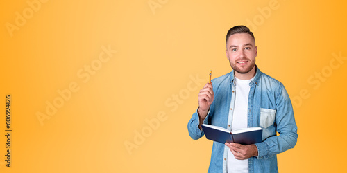 Foto Smiling man college student with notebook and pen, blue