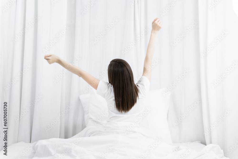 Rear view of a woman stretching her hands after wake up in the morning. Rear view of a woman stretching her hands after wake up in the morning.