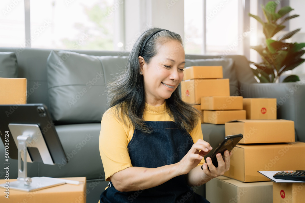 Entrepreneur using calculator calculating financial expense at home office, online market packing box delivery,Startup successful small business owner, SME, concept. Entrepreneur using calculator calculating financial expense at home office, online market packing box delivery,Startup successful small business owner, SME, concept.