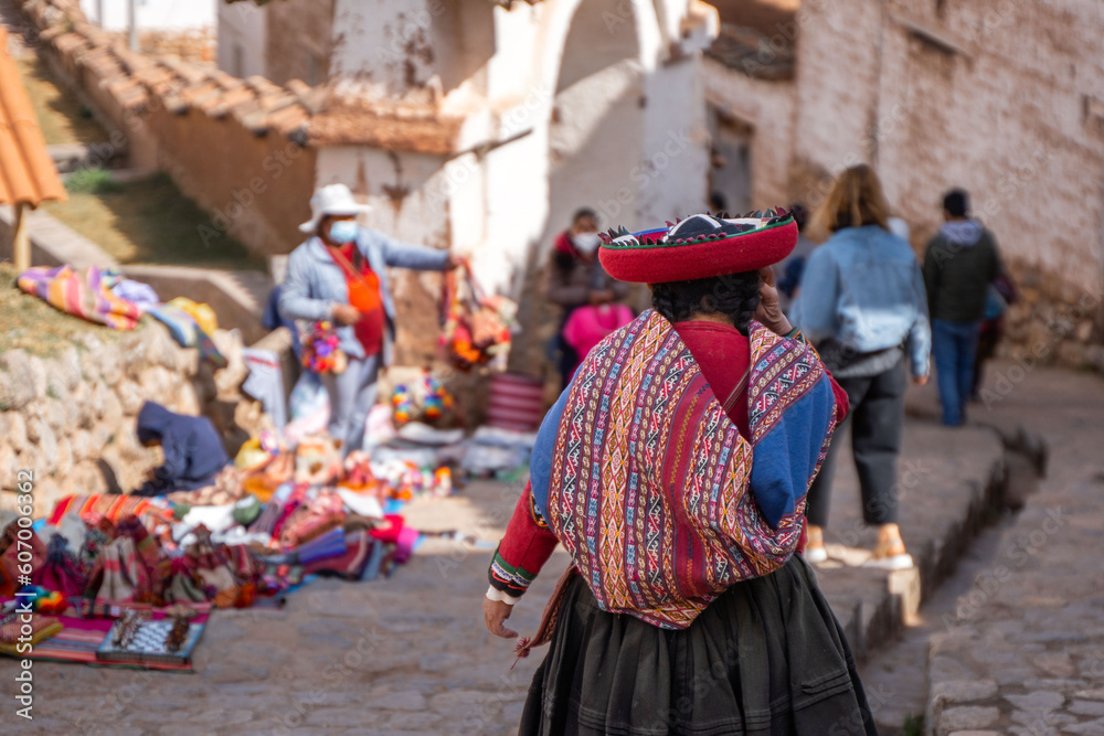 Rear view of peruvian indigenous woman dressed in traditional colorful clothes
