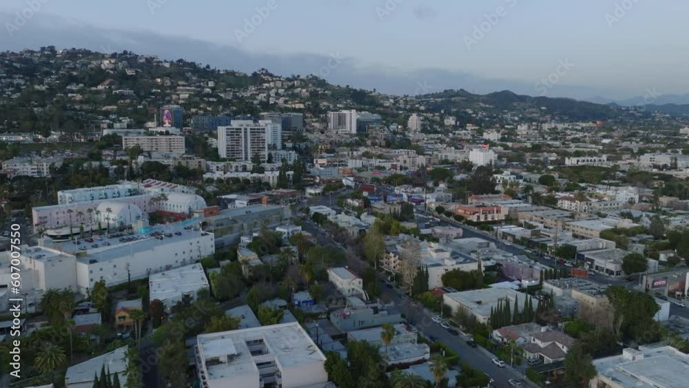 Aerial view of urban neighbourhood at twilight. Hills rising above city. Aerial view of urban neighbourhood at twilight. Hills rising above city.