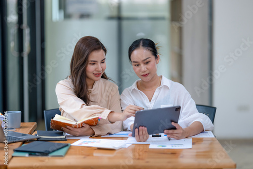 Two business women sit and discuss plans for a new project. Brainstorm and share ideas.