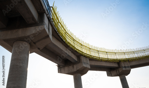 Картината върху платно A low-angle photograph of a concrete pedestrian walkway with yellow metal rails,