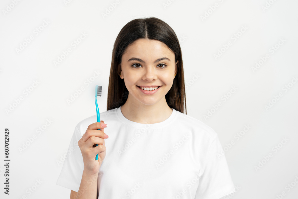 Portrait of latin beautiful smiling teenage girl holding toothbrush isolated on white background. Health care, dental concept Portrait of latin beautiful smiling teenage girl holding toothbrush isolated on white background. Health care, dental concept
