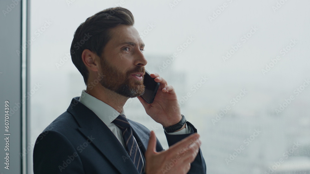 Office worker talking phone laughing at window. Man hearing good news close up. Office worker talking phone laughing at window. Man hearing good news close up.